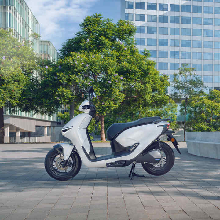 Motocicleta Honda CUV e estacionada en un entorno urbano.