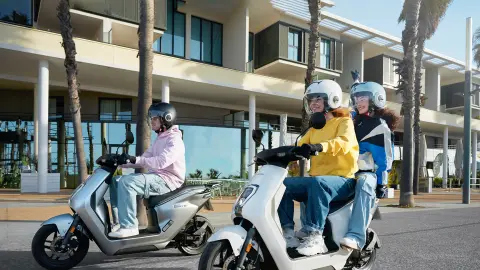 Honda EM1 e: en opciones de color gris y blanco con motociclistas en la carretera