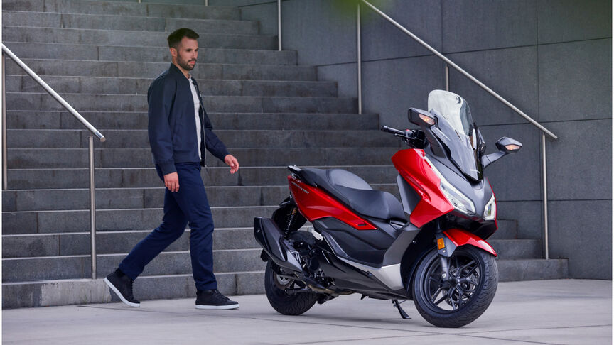 Honda Forza 350 frente a escalones con modelo 