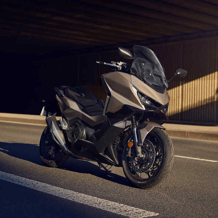 Motocicleta Forza 750 estacionada en la carretera.
