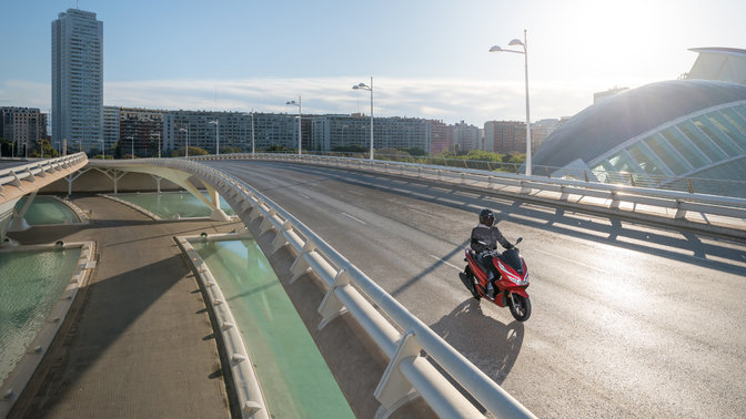 Honda PCX125 circulando por una ubicación urbana.