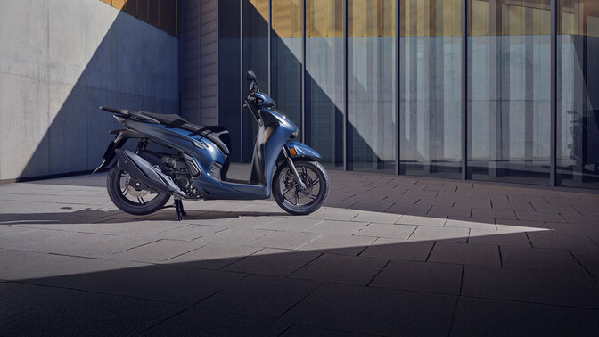 Vista lateral de la Honda 350i en un entorno de un patio. 