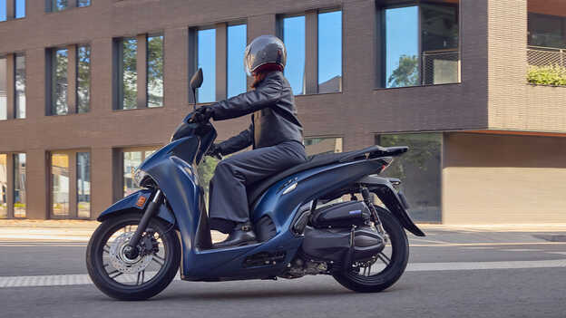 Vista lateral de un conductor en una Honda SH350 en un entorno urbano.