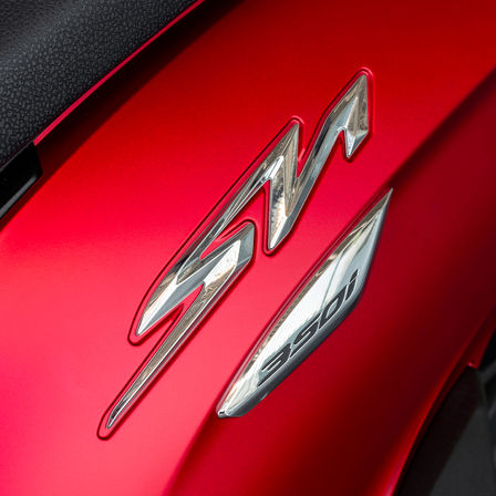 Honda SH350i, primer plano del logotipo SH, moto roja