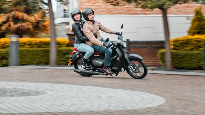 Honda Monkey sobre el caballete lateral en carretera con conductor