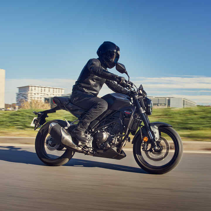 Vista lateral de la Honda CB300R circulando por la carretera.