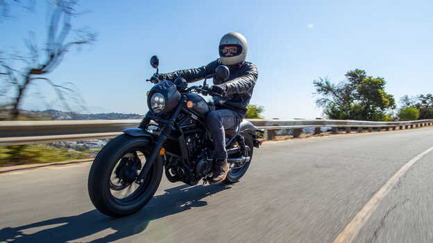 Conductor en una Honda CMX500 Rebel en carretera.