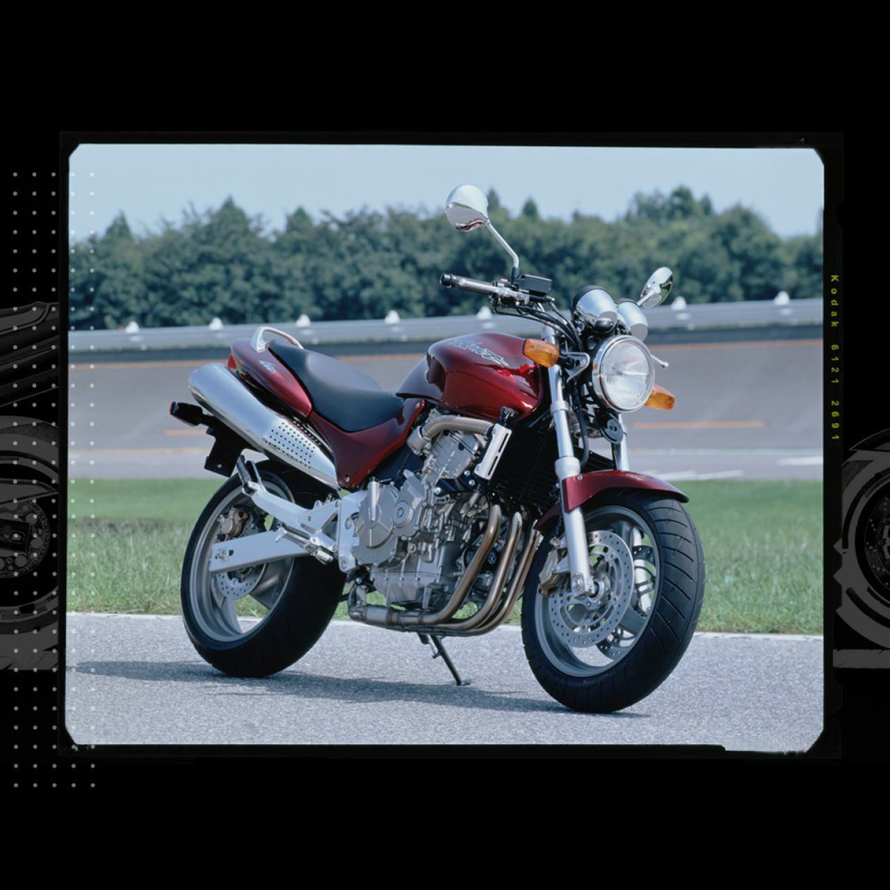 Imagen de tres cuartos de la Honda Hornet de frente aparcada en una pista de carreras.