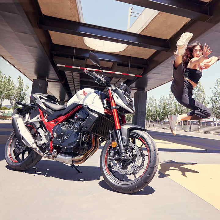 Bailarina saltando en el aire junto a la Honda CB750 Hornet.