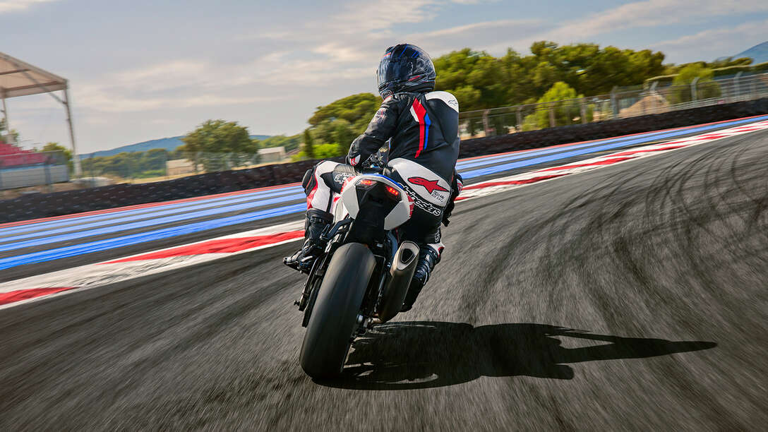 Vista trasera lateral de la Honda CBR1000RR-R-Fireblade con un motorista en una pista de carreras