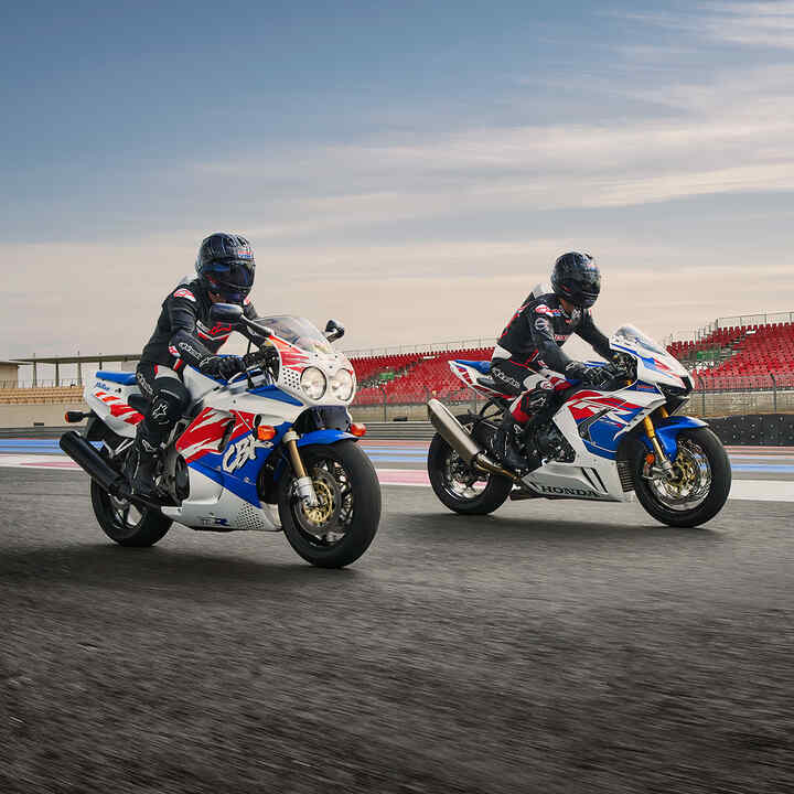 Dos motociclistas de lado mirando la Honda CBR1000RR-R-Fireblade en una pista de carreras