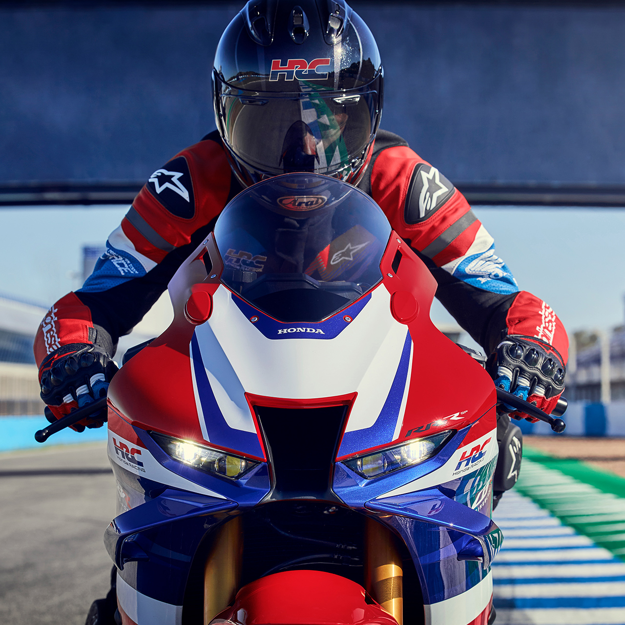 Primer plano de un piloto de frente sobre una Honda CBR1000rr-r Fireblade en la pista. 