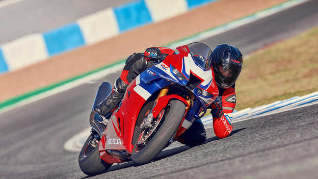 Imagen dinámica de la Honda CBR1000rr-r Fireblade en la pista con el piloto acelerando al salir de la curva.