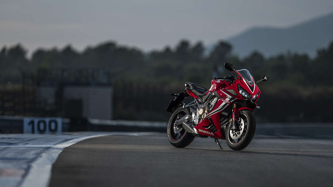 CBR650R, lateral delantero derecho de tres cuartos, en un circuito.