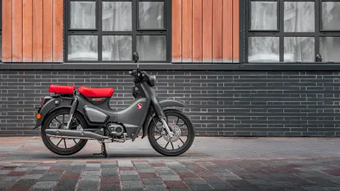 Honda Supercub 125 estática con conductor y pasajero