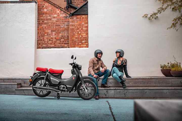 Honda Supercub 125 estática con conductor y pasajero