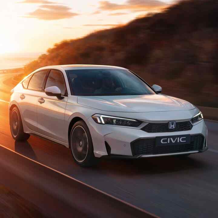 Fontal del Honda e:Ny1 conduciendo por una carretera en un lugar montañoso. 