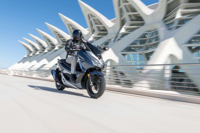 motorista con scooter honda forza azul